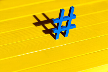 Blue hashtag on the wood yellow background