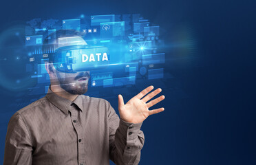 Businessman looking through Virtual Reality glasses with DATA inscription, innovative security concept