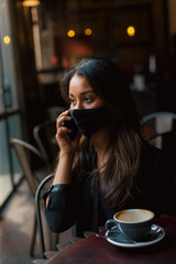 Young woman with face mask in cafe