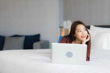 Obraz na płótnie Canvas Portrait beautiful young asian woman use computer laptop on bed