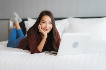 Portrait beautiful young asian woman use computer laptop on bed