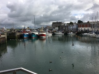 Fototapeta premium A view of Padstow Harbour in Cornwall showing the fishing boats in the evening