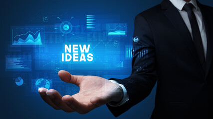 Fototapeta premium Hand of Businessman holding NEW IDEAS inscription, business success concept