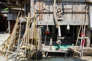An old wooden building for storing rice, there are many appliances beside it.