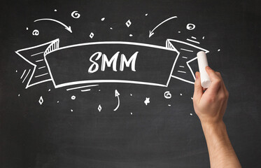 Hand drawing SMM abbreviation with white chalk on blackboard