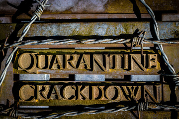 Quarantine Crackdown text formed with real authentic typeset letters on vintage textured silver...