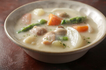 赤茶色の背景の中のクリームシチュー