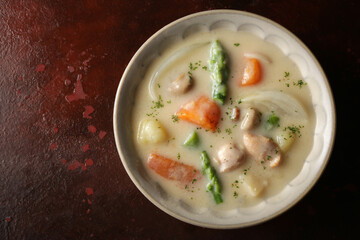 赤茶色の背景の中のクリームシチュー