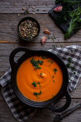 Hot pumpkin soup in cooking pot on dark background