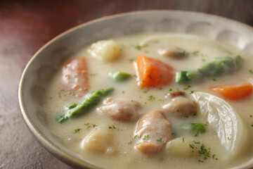 赤茶色の背景の中のクリームシチュー