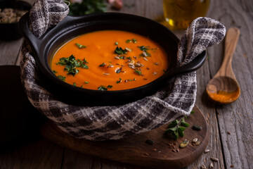 Hot pumpkin soup in cooking pot on dark background