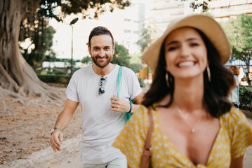 Woman with her boyfriend go to an old Valencian Ficus Macrophylla tree in Spain