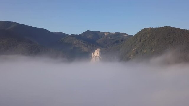 Aerial view of abandoned clifftop Strecno castle over of morning fog, Slovakia.
