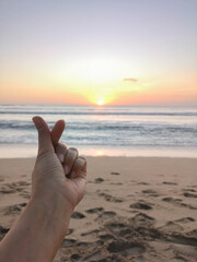 mini heart sign for love and care isolated with sunset on the beach background