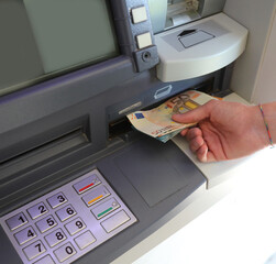 ATM with the keyboard and the hand that picks up the banknotes i