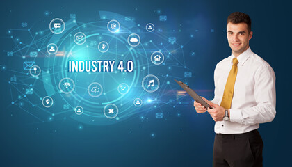 Businessman thinking in front of technology related icons and INDUSTRY 4.0 inscription, modern technology concept