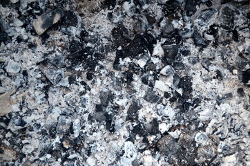 Coals in an extinct fire. Natural gray background. Coal and ash in a burnt fire