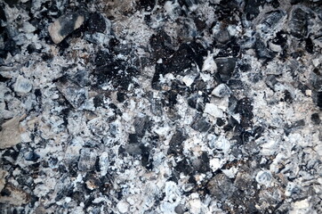 Coals in an extinct fire. Natural gray background. Coal and ash in a burnt fire