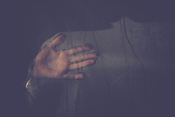 Handprint, palm on a transparent film with water drops.