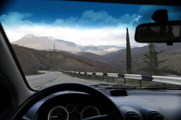 Tourism. Travel by car. View of road and mountain through the windshield. Selective focus