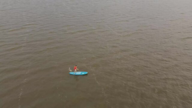 River Kayaker Aerial View. Asian Sportsman in the yellow Kayak Paddling on the Scenic River Along the Shore.