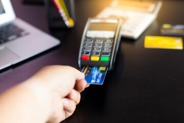 Customer holding credit card and putting it to the card payment machine
