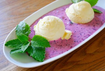 Leckeres Vanilleeis mit Blaubeersauce und Zitronenmelisse