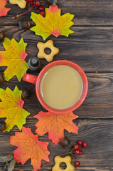 Autumn background warming cocoa drink and autumn leaves on wooden background with copy space for text or design