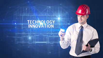 Handsome architect with helmet drawing TECHNOLOGY INNOVATION inscription, new technology concept