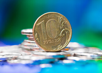 Russian money. 10 roubles close-up, and other coins against green and blue background