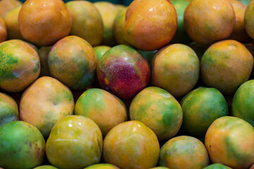 A counter with a nested pile of ripe mangoes. Selective focus. Exotic fruits of Asia. 