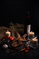 Delicious pork chop steak served on wooden board for a romantic dinner in dark tone with copy space.