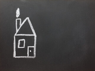hand chalk drawing of house  on a black blackboard with copy space for text