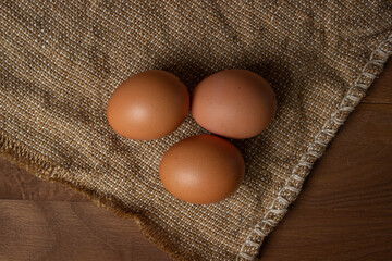 The eggs are on the sacking. Brown chicken eggs.