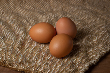 The eggs are on the sacking. Brown chicken eggs.