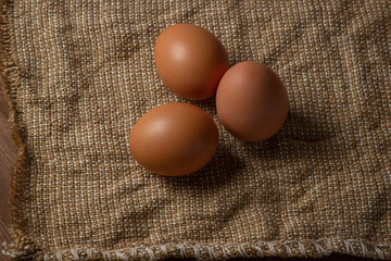 The eggs are on the sacking. Brown chicken eggs.