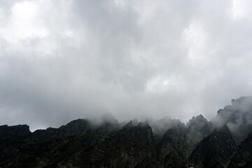 
The peaks of the High Tatras with white clouds. Mountains in the clouds. High Tatras Mountains in Slovakia