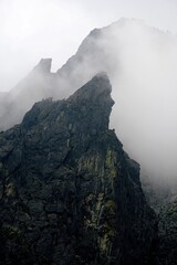 
The peaks of the High Tatras with white clouds. Mountains in the clouds. High Tatras Mountains in Slovakia