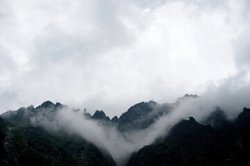 
The peaks of the High Tatras with white clouds. Mountains in the clouds. High Tatras Mountains in Slovakia