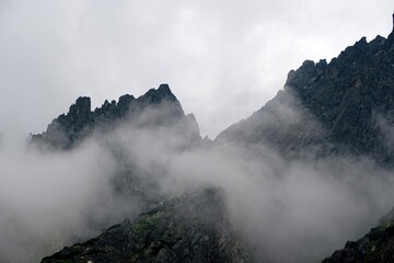 
The peaks of the High Tatras with white clouds. Mountains in the clouds. High Tatras Mountains in Slovakia