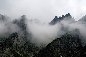 
The peaks of the High Tatras with white clouds. Mountains in the clouds. High Tatras Mountains in Slovakia