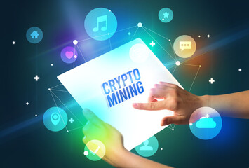 Holding futuristic tablet with CRYPTO MINING inscription, new technology concept