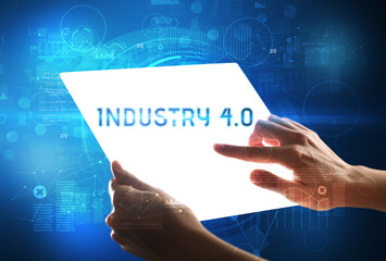 Hand holdig futuristic tablet with INDUSTRY 4.0 inscription, new technology concept