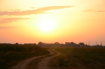 Obraz premium Sunrise in the field above the road.