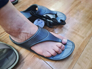Close-up Lower Section of Woman Fitting Rubber Sandals at Store