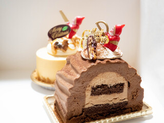 クリスマスケーキの上でノコギリをひいて準備をするサンタクロース