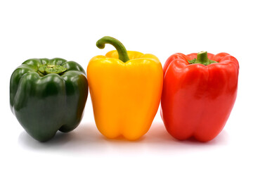 Green, yellow and red bell pepper on the light background.