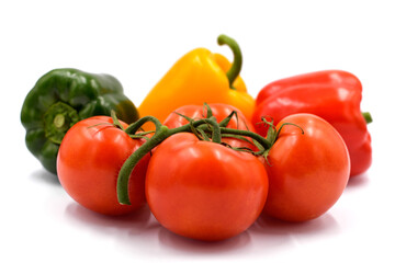 Red tomatoes and peppers on the light background.