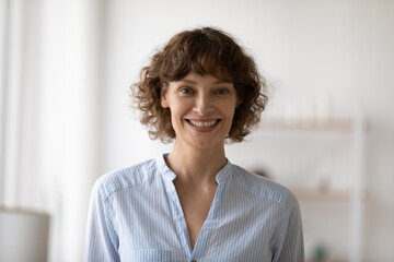Profile picture of smiling caucasian 40s woman look at camera posing at home. Headshot portrait of...