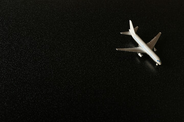 Fototapeta na wymiar tourism concept with copy space. toy airplane on dark black background